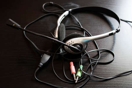Headphones and wire on a wooden table close upの写真素材