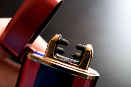 Metal red electric lighter in hand close upの写真素材
