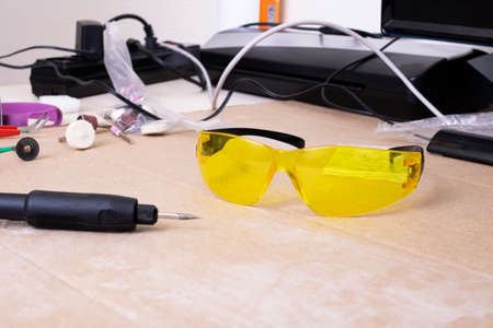 Engraver and yellow protection glasses on the desktopの写真素材