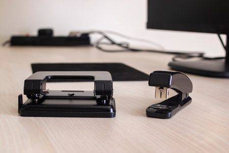 Black hole punch and stapler on the desktop close up