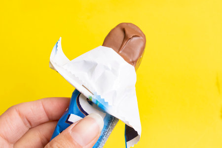 BELARUS, NOVOPOLOTSK - 12 APRIL, 2021: Bounty bar in hand on yellow background close upのeditorial素材