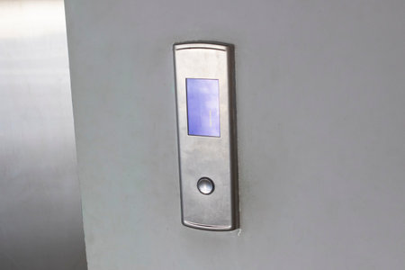 Gray metal elevator button on the wall close up