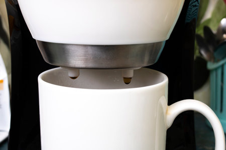 White coffee maker with two mugs on white background close upの写真素材