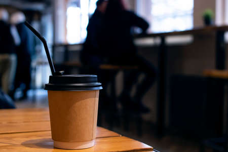 Paper coffee cup on table in cafe close upの写真素材