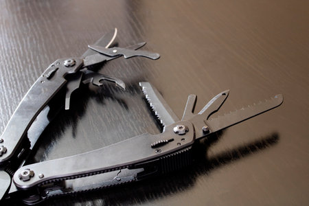 Black multi tool on wooden table close upの写真素材
