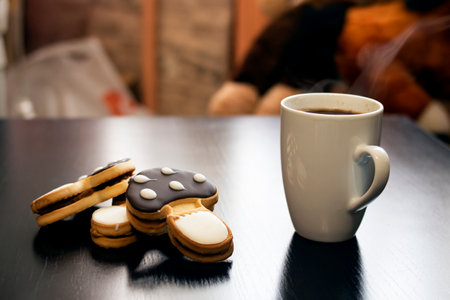 Mushroom shaped cookies and cup of coffee on a wooden table close up