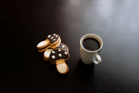 Mushroom shaped cookies and cup of coffee on a wooden table close upの写真素材