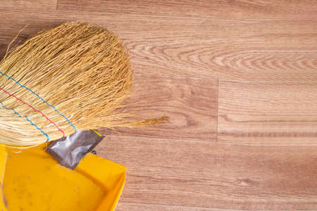 Broom and scoop removes garbage on wooden floor copy spaceの写真素材