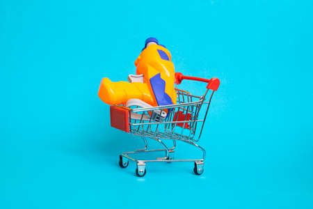 Water gun in a shopping basket on a blue background close up