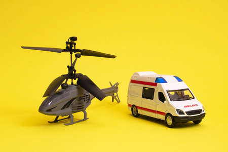 Toy ambulance and helicopter on yellow background close upの写真素材