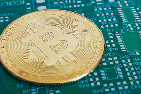 Bitcoins on green circuit board background close upの写真素材