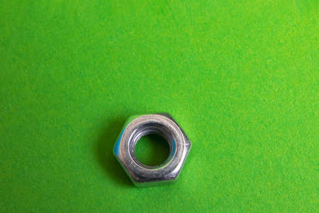 Metal nut on a green background closeup, copy spaceの写真素材