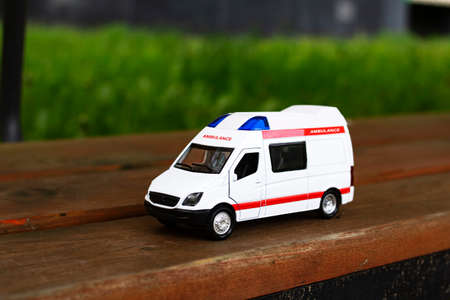 Ambulance car on the asphalt among the trees close up