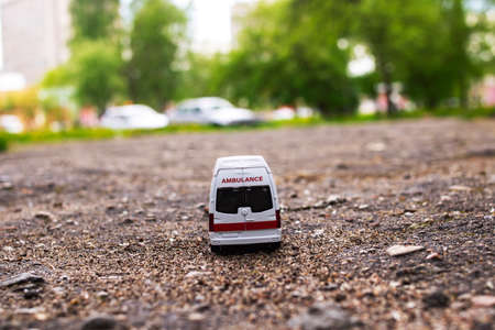 Ambulance car on the asphalt among the trees close up