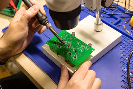 Soldering process on a green PCB close up