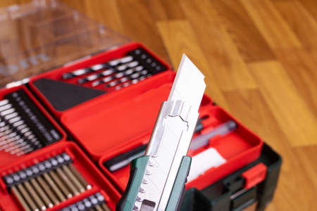 Stationery knife on the background of a bit for a screwdriverの写真素材