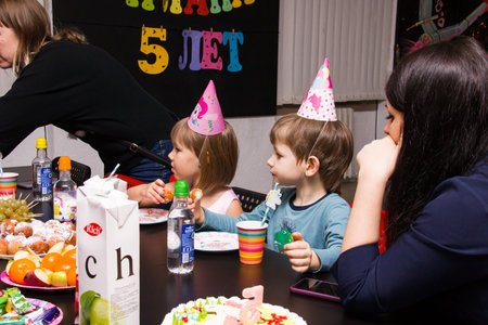 BELARUS, NOVOPOLOTSK - 30 DECEMBER, 2020: Children at the table eating cake at the holiday close upのeditorial素材