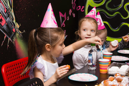BELARUS, NOVOPOLOTSK - 30 DECEMBER, 2020: Children at the table eating cake at the holiday close upのeditorial素材