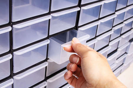 Plastic cells in the small change box and hand close up