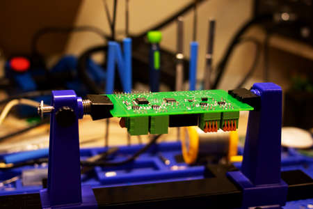 Soldering process on a green PCB close up