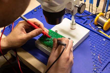 Soldering process on a green PCB close up