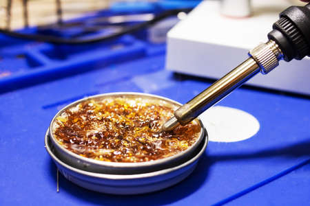 Hot soldering iron and yellow rosin close up