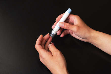 The lancet device pierces the finger close upの写真素材