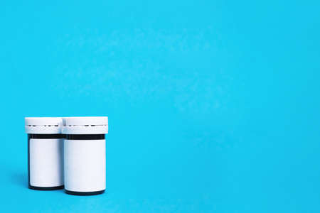 Two jars of medicines on a blue background, copy spaceの写真素材