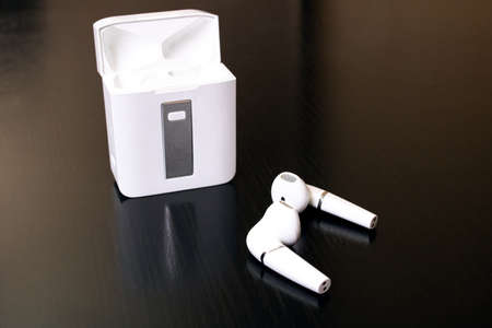 Wireless earbuds on a wooden table close up