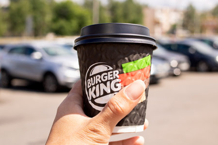 BELARUS, NOVOPOLOTSK - 02 JULE, 2021: Plastic cup with the inscription Burger King in hand close up