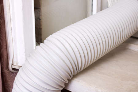 Corrugated pipe from the air conditioner on the windowsill close upの写真素材