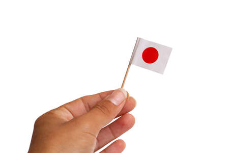 Small japanese flag in hand isolated on white background close upの写真素材