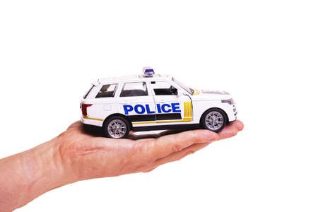 Toy police car on palm isolated on white background close up
