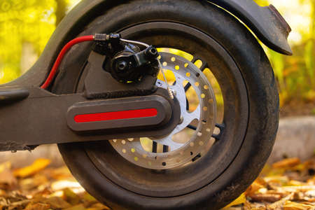 Electric scooter in yellow autumn leaves close upの写真素材