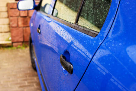 Blue car door handle with rain drops close upの写真素材