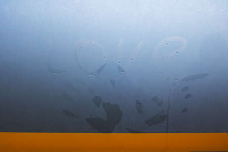 Palm print and inscription love on a wet glass close upの写真素材
