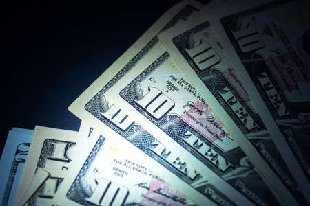 Stack of 10 dollar bills in the dark close upの写真素材