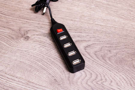 Black USB hub on a wooden background close upの写真素材
