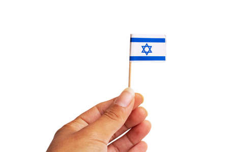 Small Israel flag in hand close up, isolated on white backgroundの写真素材