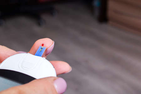 Female hands and glucometer measuring blood sugar copy spaceの写真素材