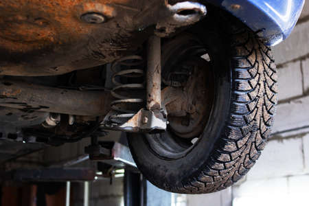Car on a lift in a car service, wheel close upの写真素材