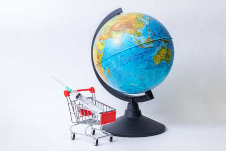 Globe and syringe in a shopping cart on a white backgroundの写真素材