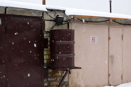 Large tin barrel hanging on the wall in snow