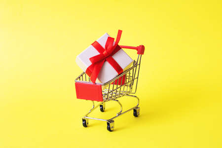 White box with a gift in shopping cart close upの写真素材