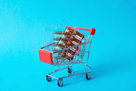Ampoules with medicine in shopping cart close up