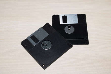 Two floppy disks on a wooden table close up
