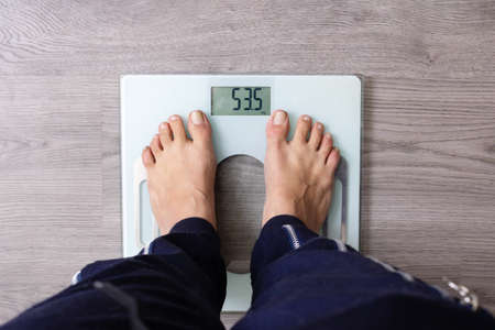 Young Woman Standing On Weighing close up, Top View