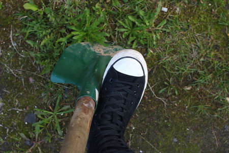 Foot on a shovel, the concept of gardening close up