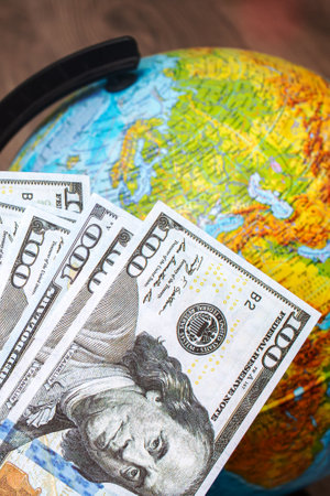 Stack of dollars on a background of a globe with a map