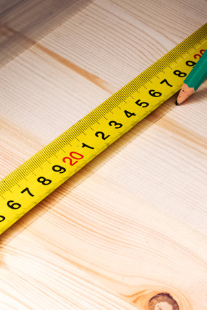 Marking with a pencil and a ruler on a wooden board close upの写真素材